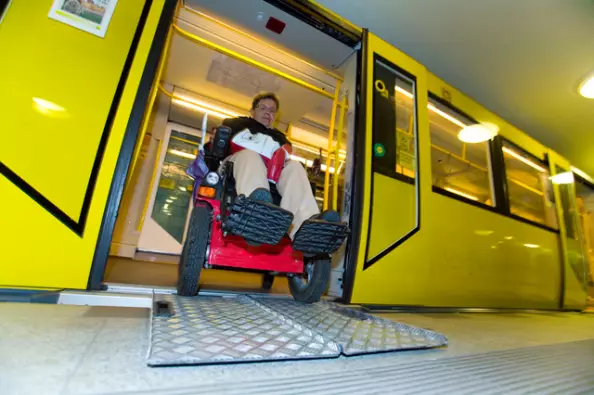 Foto: Rollstuhlfahrer schiebt Rollstuhl aus geöffneter Tür einer gelben U-Bahn der BVG