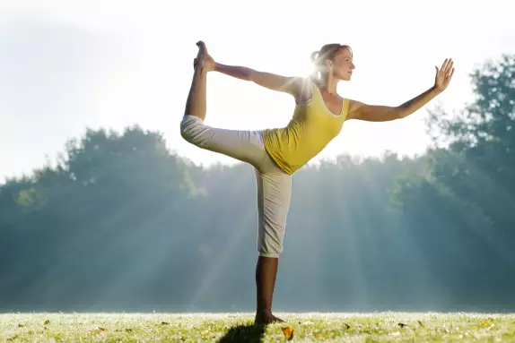 Frau praktiziert YOGA im Park Frau praktiziert YOGA im Park im Sonnenschein