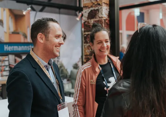 Employees of the visitBerlin Berlin Convention Office talking to partners at a trade fair