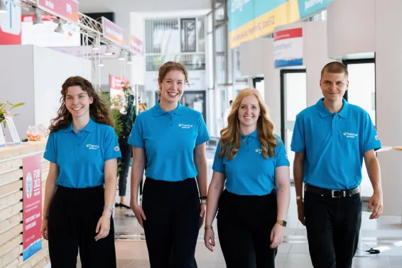 Dynamisches Interplan Kongress-Team kommt lachend entgegen.