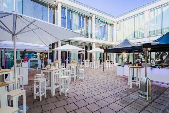 Meeting Guide Berlin Cafe Moskau Innenhof mit Sonnenschirmen und Stehtischen