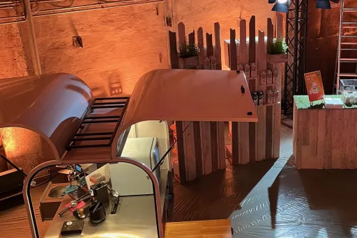 Messestand im rustikalen Stil mit Holzdekor und warmem Licht.