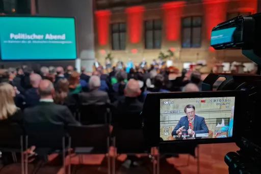 Blick durch die Kameralinse auf eine Podiumsdiskussion beim politischen Abend des DKK 2024; im Fokus der ehemalige Gesundheitsminister Prof. Karl Lauterbach.