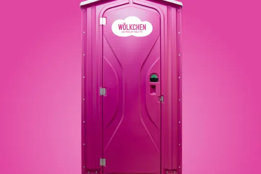 EIne pinke Wölkchen WC-Kabine mit dem Logo, der weißen Wolke. Diese wird durch einen zarten, pinken Hintergrund hervorgehoben.