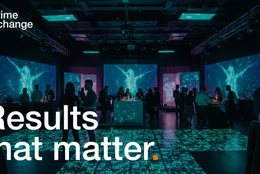 Menschen stehen in beleuchtetem Eventraum mit digitalen Leinwänden und Bodenprojektionen.