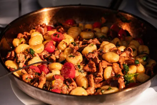 Pfanne mit Gnocchi, Pilzen, Tomaten und frischen Kräutern
