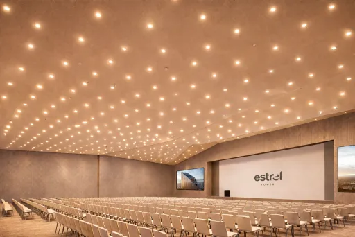 Großer, heller Konferenzraum mit vielen Stuhlreihen und beleuchteter Decke.