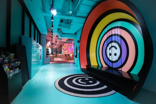Bunter, moderner Eingang zum Upside-Down-Erlebnis mit Regenbogenkreisen und einem Upside-Down-Teppich.