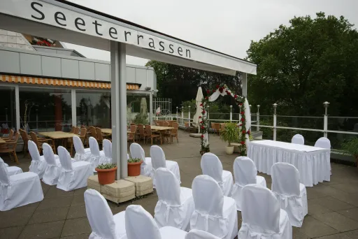 Terrasse der Tegeler Seeterrassen am Tegeler See mit Rosenbogen und festlich eingedeckter Hochzeitstafel