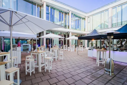 Meeting Guide Berlin Cafe Moskau Innenhof mit Sonnenschirmen und Stehtischen