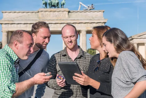 Team mit iPad am Brandenburger Tor in Berlin