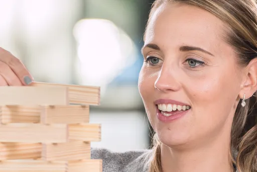 Frau baut mit Kapla Steinen