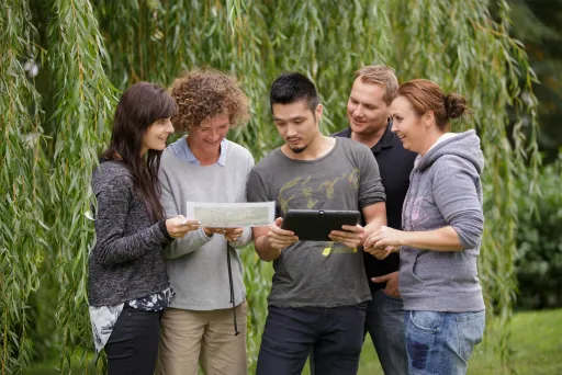 Meeting Guide Berlin Teamgeist Team mit iPad und Karte im Grünen