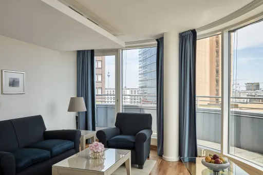 Helles Wohnzimmer mit zwei Sofas, großem Fenster und Blick auf die Stadt