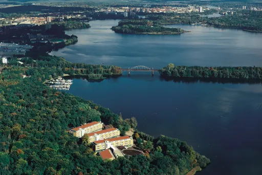 Seminaris SeeHotel Potsdam Birdview, weiter Seeblick und Hotel ragt zwischen Bäumen hervor im Vordergrund