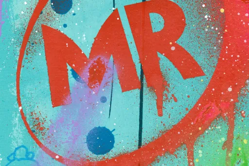 Rotes „MR“ auf bunt besprühter Wand mit blauem Hintergrund