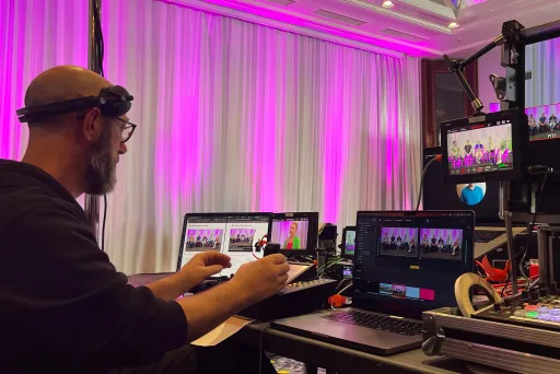 eine Person, die von Streaming-Geräten umgeben ist, steuert eine Kamera.