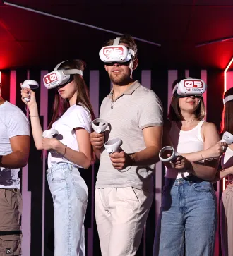 Five people wearing VR headsets and holding controllers in a neon-lit room.