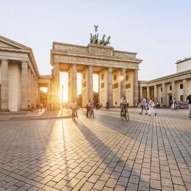 Brandenburger Tor bei Sonnenuntergang mit Berlin Touristen und Fahrradfahrern