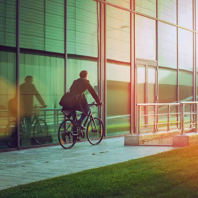 Business Mann auf einem Fahrrad für eine nachhaltige Veranstaltungsplanung mir Sustainable Meetings Berlin