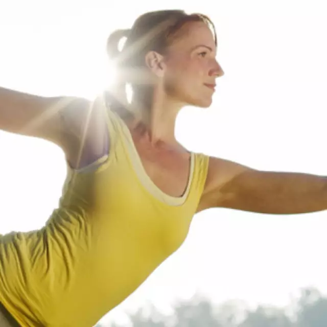 Frau praktiziert Yoga im Park bei Sonnenschein