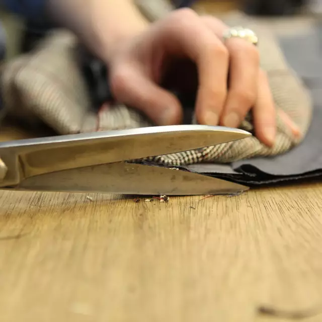 Tailor tailors made-to-measure clothing using scissors