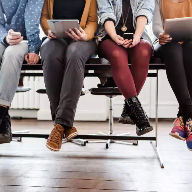 Young businessmen with tablets and smartphones sit on a table
