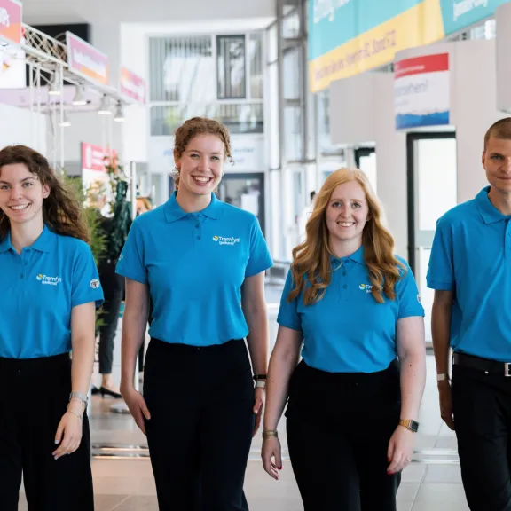 Dynamisches Interplan Kongress-Team kommt lachend entgegen.