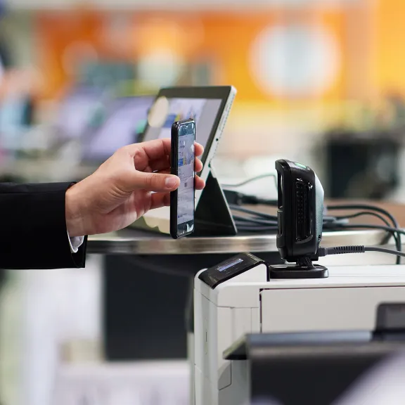 Scanner auf den eine Hand mit einem Smartphone gerichtet ist