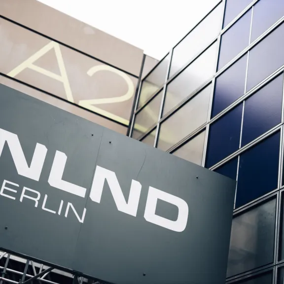 Modernes Gebäude mit großem Schild „NLND BERLIN“ und Glasfassade