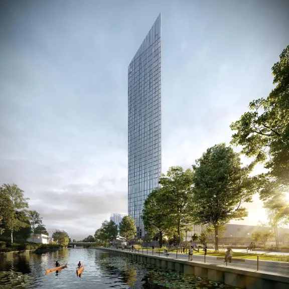 Hohes, modernes Hochhaus am Fluss, umgeben von Bäumen und Spaziergängern.