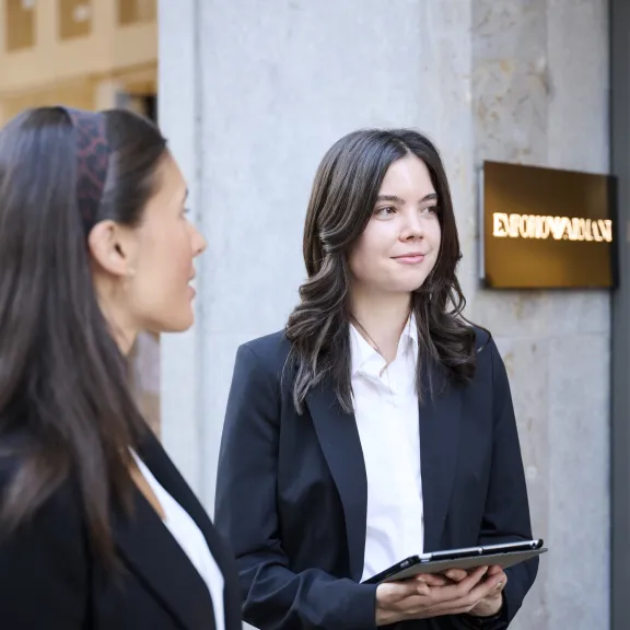 Zwei Frauen in schwarzen Blazern stehen vor einem Laden, eine hält ein Tablet – Eventpersonal und Promotionteam im Einsatz.