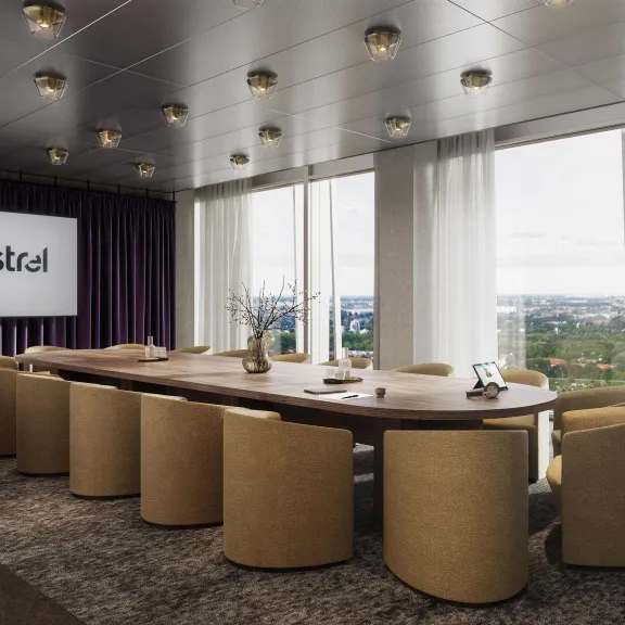 Moderner Konferenzraum mit großem Holztisch, beigen Stühlen und Panoramafenstern.