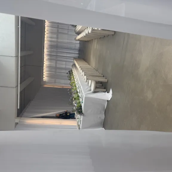 Langer, dekorierter Esstisch mit weißen Stühlen in einem hellen Saal.