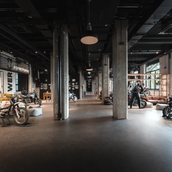 Geräumiger Motorradausstellungsraum mit mehreren Motorrädern und großen Fenstern.
