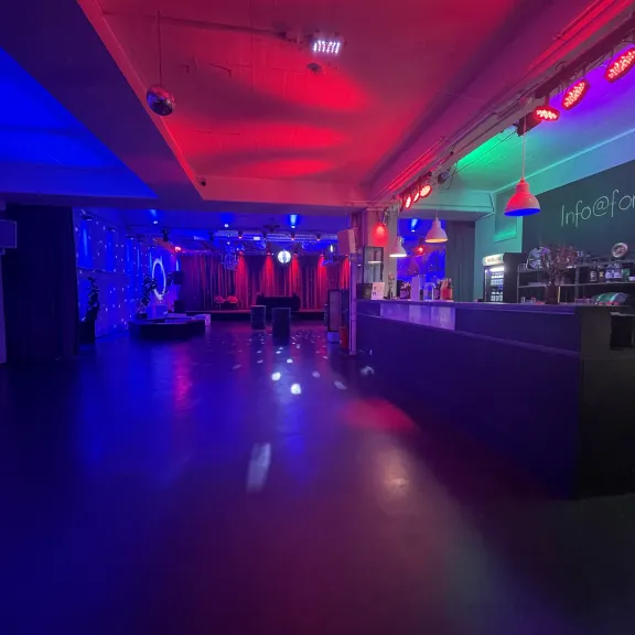 Forum Factory mit  bunter Beleuchtung und Spiegelkugel: Die Bar auf der rechten Seite, die großzügige Eventfläche im Fokus