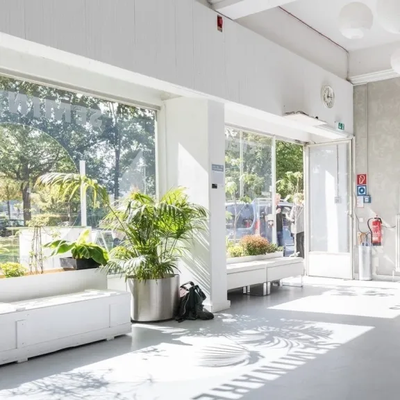Heller, moderner Empfangsbereich der Forum Factory Berlin mit Pflanzen und großen Fenstern.