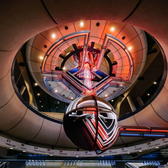 Futuristisches Gebäude mit runden Formen und leuchtenden roten Lichtern.