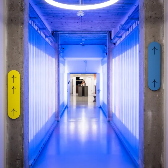 Modern beleuchteter Flur mit blauem Licht und rundem LED-Leuchtring an der Decke.