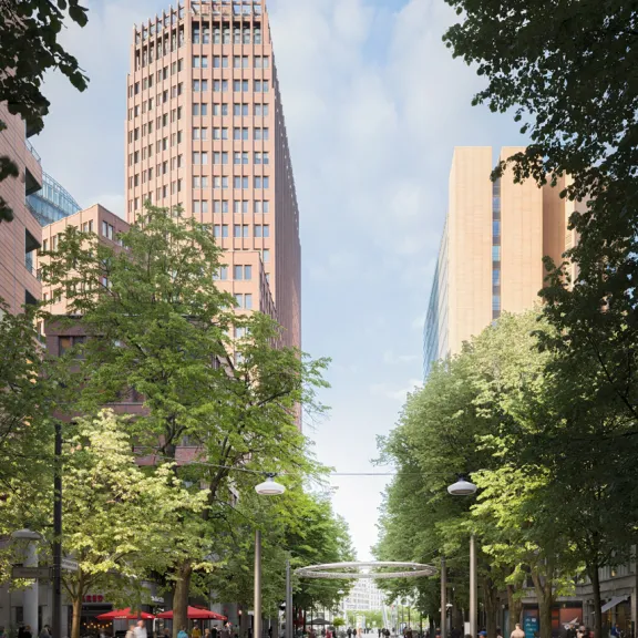 Breite Fußgängerzone mit Bäumen, hohen Gebäuden und Menschen bei Tageslicht.