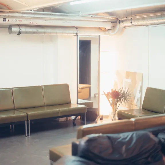 Zwei grüne Sofas in einem spärlich beleuchteten Backstage