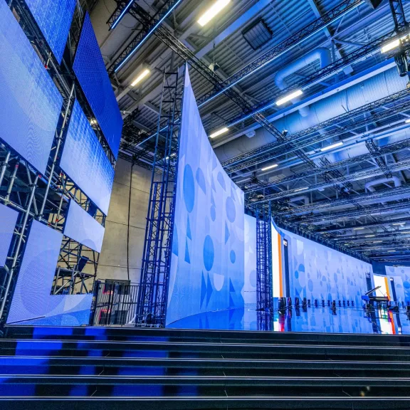 Große Bühne mit blauer Beleuchtung und modernen Strukturen, leerer Saal