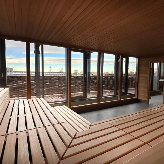 Sauna mit Holzverkleidung, großen Fenstern und Ausblick auf den Fernsehturm.