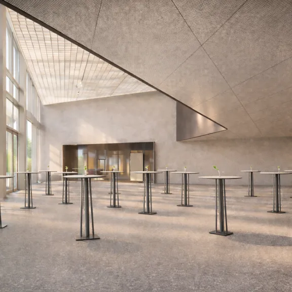 Heller, moderner Innenraum mit hohen Stehtischen und großen Fenstern