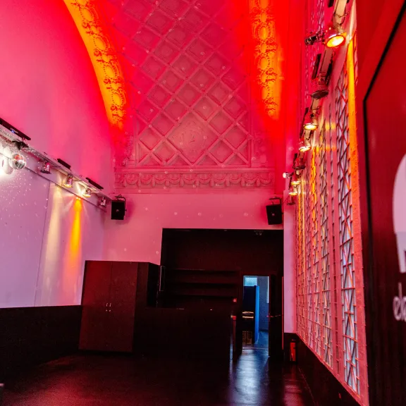 Leerer Clubraum mit roter Beleuchtung und Elefantenlogo an der Wand