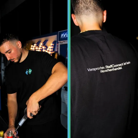Junger Mann mit schwarzem T-Shirt, vorne mit Logo, hinten mit weißem Schriftzug.