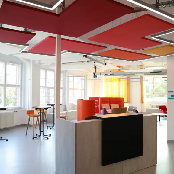 Modernes Büro mit bunten Akustikpaneelen und hellen Sitzbereichen