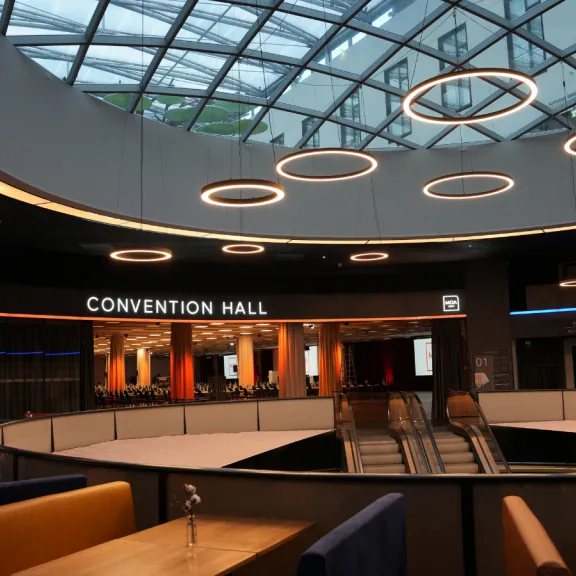 Modernes Foyer mit Glasdach, runden Deckenleuchten und Aufgang zur Convention Hall.