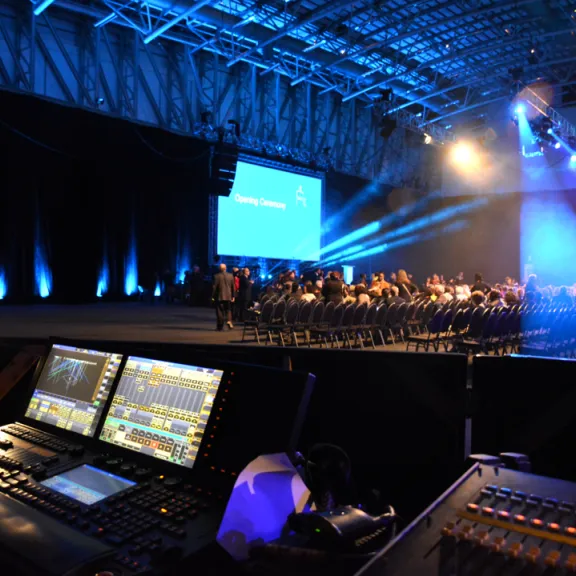 Ton- und Lichttechnikpult bei einer beleuchteten Bühnenshow in großer Halle