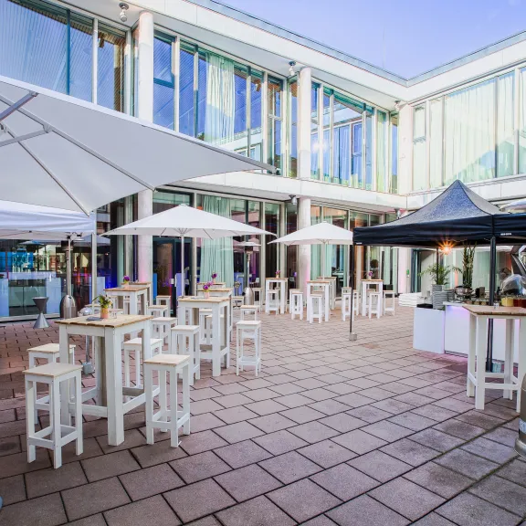 Meeting Guide Berlin Cafe Moskau Innenhof mit Sonnenschirmen und Stehtischen